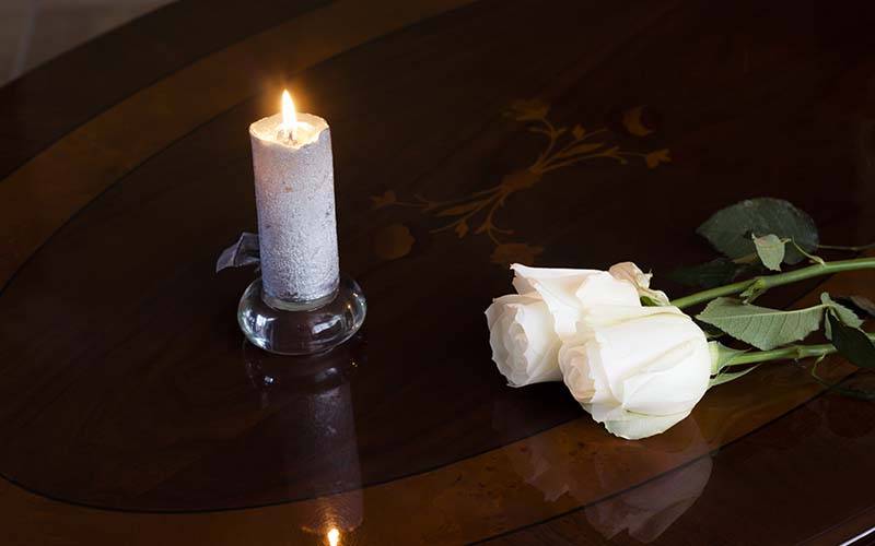 candle and roses on a table in the chapel of rest