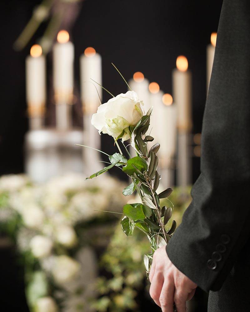 man at a funeral holding a flower